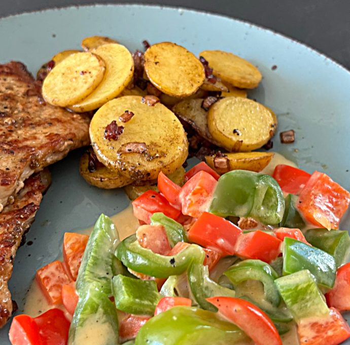 Schweinerückensteak mit Bratkartoffeln und Paprikagemüse